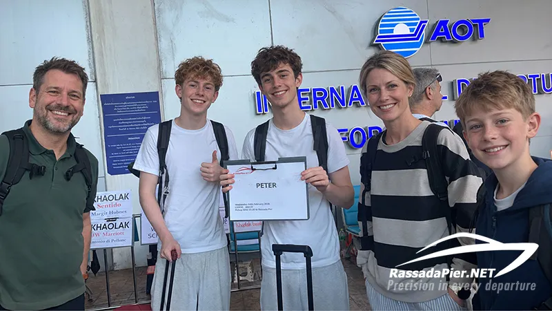 A happy family met by their private airport transfer driver at Phuket International Airport (HKT) before heading to Rassada Pier for their boat to Phi Phi Island, featuring their name sign PETER.
